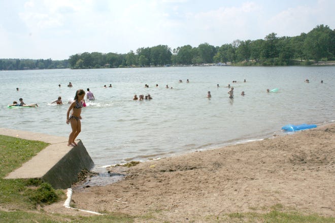 Area families battle Wednesday's heat by spending the day at Sandy Beach at Baw Beese Lake.