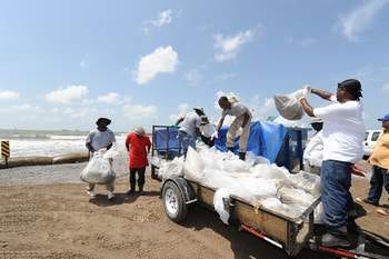 Workers continue to clean up the oil on the beach at Port Fourchon, La., Thursday, July 8, 2010.