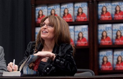 In this Dec. 3, 2009 file photo, former Alaska Gov. Sarah Palin signs a copy of "Going Rogue" during a book signing event at a Sam's Club in Fayetteville, Ark. A year after her abrupt resignation as Alaska governor, Palin has evolved into a political personality writ large, commanding weeks of headlines for a single Facebook observation _ see health care "death panels" _ and six-figure speaking fees from groups clamoring for her words. Going rogue with a best-selling memoir only added to her aura among the conservative faithful and she has easily eclipsed other Republicans as the coveted endorsement this election year.