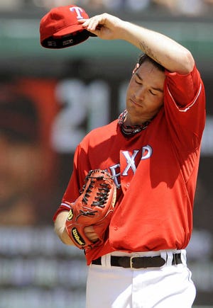 Texas Rangers starting pitcher C.J. Wilson reacts after delivering a pitch to the Baltimore Orioles during a baseball game Sunday, July 11, 2010, in Arlington, Texas. The Orioles defeated the Rangers 4-1. (AP Photo/Cody Duty)