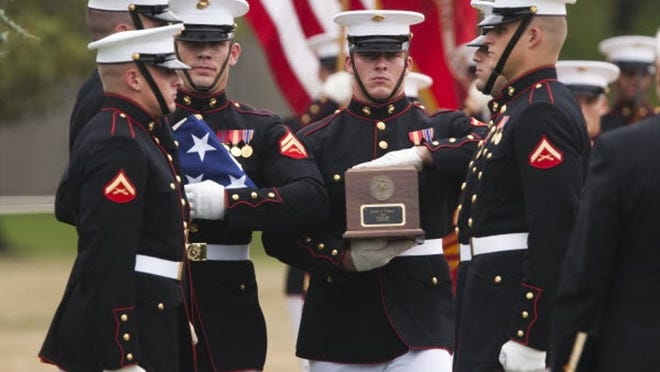 Marines conducting military honors, prepare to place Lance Cpl. Justin J. Wilson's remains to rest during Wilson's burial service at Arlington National Cemetery in Arlington, Va.