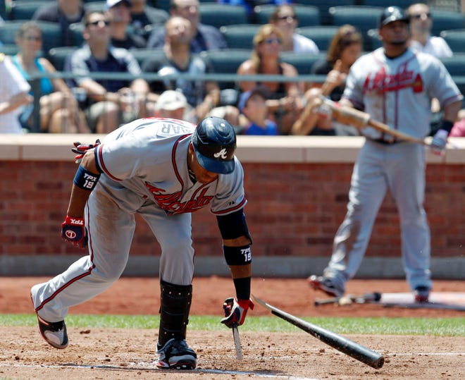 Atlanta Braves' Yuniel Escobar, left, breaks his bat after he fouled out, stranding two runners in the fourth inning of the Braves' 3-0 loss to the New York Mets in a baseball game in New York, Sunday, July 11, 2010. (AP Photo/Kathy Willens)