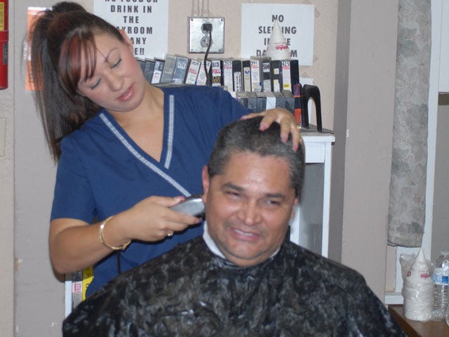 Steven Agcaoili gets a haircut from Barstow Community College student Priscilla Carrillo at Desert Manna on Monday. The college’s Cosmetology Club offered free haircuts to the homeless as a way to serve the community and complete their college requirements.