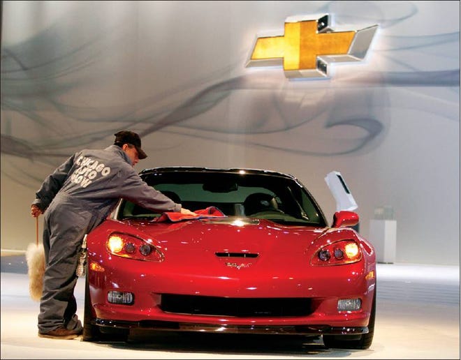 NEW TWIST: An auto show worker cleans the hood of a 2011 Chevrolet Corvette ZR1 at the 2010 Chicago Auto Show in Chicago in February. General Motors Co. said Monday, buyers who order a 2011 Corvette Z06 or ZR1 can help assemble their cars’ high-performance engines at a facility outside Detroit.