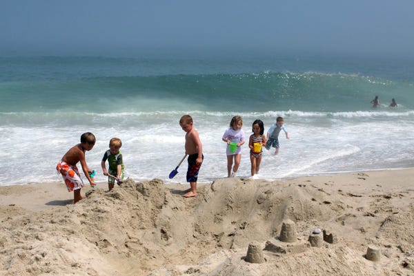 ORLEANS -- 07/13/10 -- Jack Wilson, 8, Justin Major, 3, Zachary Major, 6, Sarah Major, 6, Charlotte Wilson, 5, and Jackson Ryan, 7, all enjoying a Cape vacation, enjoy making a sand pool at Nauset Beach. People packed the beach even though a great white shark has been seen only a few miles away. 071310