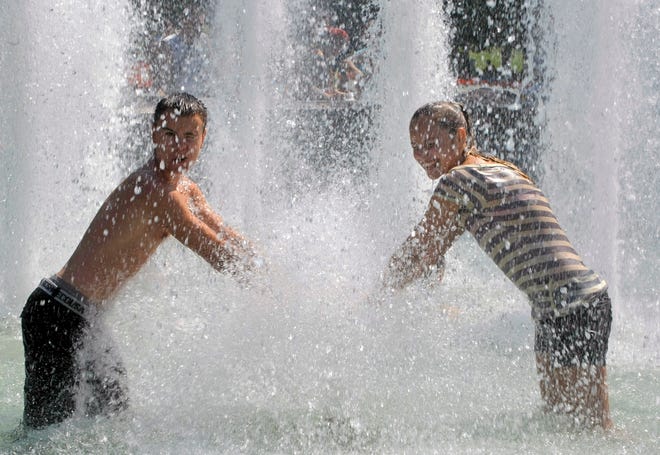 Young people enjoy a cooling splash in a Moscow fountain on Thursday. A 
state of emergency has been declared in 18 Russian provinces.AP PHOTO /