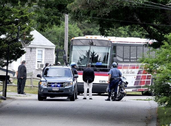Police officers stand by during a jury’s visit yesterday to General Patton Drive in Hyannis, where Jacques Sellers was shot and killed in 2007. The jury will deliberate the fate of second-degree murder suspect Julian Green.