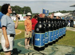 Photo by Anna Murphey/New Jersey Herald Reenee Casapulla, recycling, marketing coordinator/safety officer at the Sussex County Municipal Utilities Authority, presents the new recycling containers to county officials before the Sussex Skyhawks game at Skylands Park Saturday evening. The containers have a new look with the new logo.