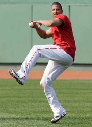Boston Red Sox catcher Victor Martinez, who is on the disabled list after fracturing his left thumb, works out in the outfield without a glove prior to a baseball game against the Texas Rangers in Boston, Friday, July 16, 2010.