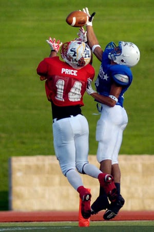 East's Anthony Cook, left, knocks the ball from West's Jacob Hancock as he attempts to dive into the end zone during the first quarter of their Six Man All-Star football game, Friday at Lowrey field.Friday, July 16, 2010. (Geoffrey McAllister/Lubbock Avalanche-Journal)