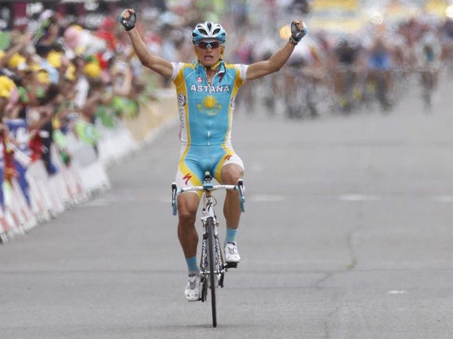 Alexandre Vinokourov of Kazakhstan crosses the finish line to win the 13th stage of the Tour de France cycling race over 196 kilometers (121.8 miles) with start in Rodez and finish in Revel, France, Saturday, second ahead of the sprinting pack, rear.