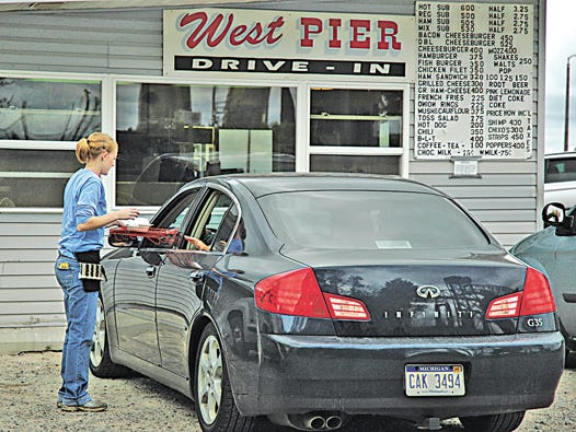 Sault Ste. Marie resident Jessica Earns brings her customers their tasty food on Saturday, as the hungry group waits for their burgers and other treats at West Pier.