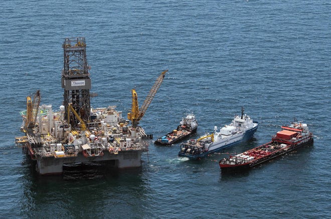 Work boats operate next to the Transocean Development Driller III at the site of the Deepwater Horizon oil spill in the Gulf of Mexico Saturday.