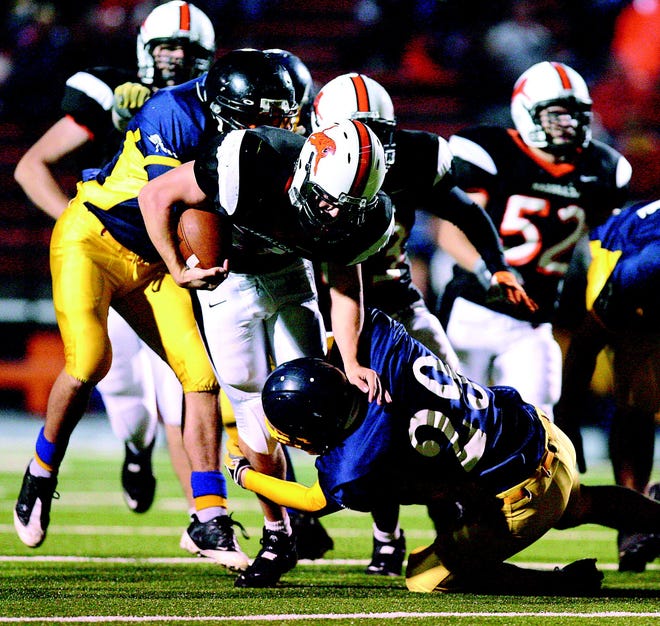 Massillon's Seth Nalbach tries to get through the tackle of Brantford (Ont.) Collegiate's Jimmy Scheel, rear, and Joey Kitchen, front, during a 2008 game.