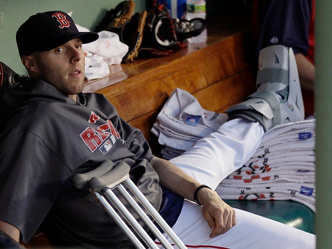 With his broken left foot in a cast, Boston Red Sox second baseman Dustin Pedroia finds a comfortable spot to watch the baseball game during the sixth inning against Baltimore Orioles at Fenway Park in Boston, Friday, July 2, 2010. Pedroia broke his foot last week and is expected to be on the disabled list for about six weeks.(AP Photo/Charles Krupa)