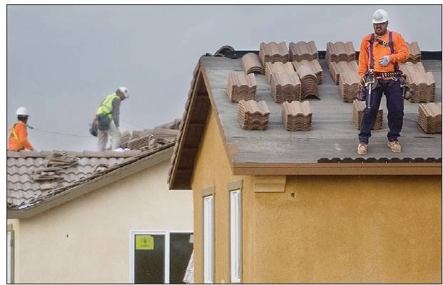 LOOKING HEAD: Roofers work on new homes in a new KB Homes development near Papago and Chumash in Victorville this spring. Home builders are becoming pessimistic about the next several months for the new-home market.