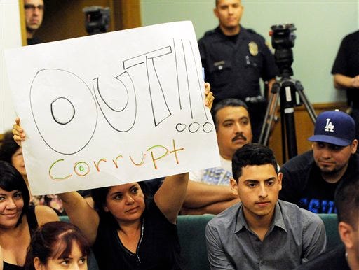 A resident of Bell, Calif,. holds up a placard calling for the ouster of city officials during a special city council meeting, Thursday, July 22, 2010, in Bell, Calif. Council members emerged from an hours-long closed session at midnight Friday and announced that they'd accepted the resignations of Chief Administrative Officer Robert Rizzo, Assistant City Manager Angela Spaccia and Police Chief Randy Adams. Rizzo was the highest paid at $787,637 a year _ nearly twice the pay of President Barack Obama _ for overseeing one of the poorest towns in Los Angeles County. Spaccia makes $376,288 a year and Adams earns $457,000, 50 percent more than Los Angeles Police Chief Charlie Beck. (AP Photo/Chris Pizzello)
