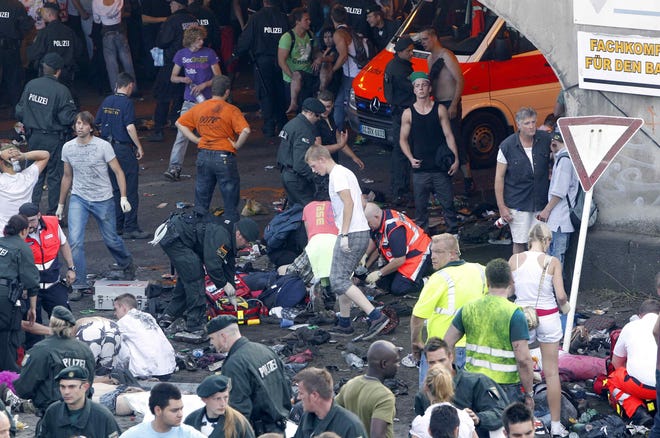 Collapsed people get first aid after a panic on this year's techno-music festival "Loveparade 2010" in Duisburg, Germany, on Saturday, July 24, 2010. German police say that 10 people were killed and 15 others injured when mass panic broke out in a tunnel at the Love Parade. (AP Photo/dapd/Hermann J. Knippertz)