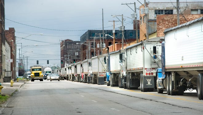 Southbound trucks wait on Washington Street on Wednesday for the opportunity to turn east on Persimmon Street en route to the Archer Daniels Midland plant.