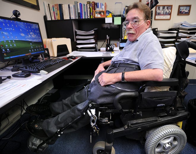 Paul Spooner, Executive Director of the MetroWest Center for Independent Living, works at his desk in Framingham.