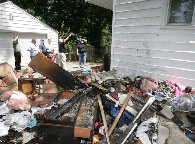 Massillon building and fire department officials, along with an insurance adjustor, meet with family members at a home on Lake Avenue to assess the amount of damage a weekend fire caused.