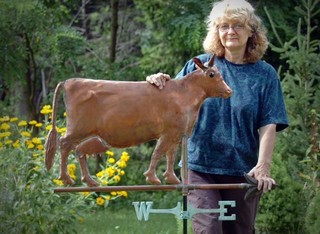 Marian Ives, who makes weather vanes, shows off one of her copper creations. Ives designs and manufactures one-of-a-kind weather vanes, wall hangings and more.