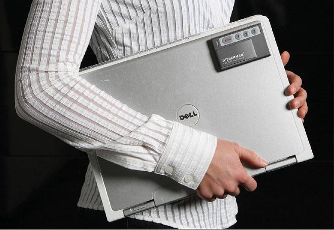 SUPPLIES: Doberman Security Laptop Defender motion sensor alarm is attached to a laptop computer.