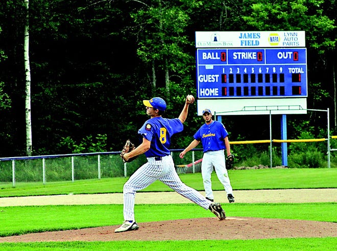 Keane Cairns of the EUP?Travelers pitches, while third baseman McKinley Portice looks on from the background during Tuesday’s game against the Soo Black Sox. A new scoreboard has been installed in the leftfield corner of the James’ diamond. Funds for the scoreboard were donated by local businesses, with the primary sponsors including Lynn Auto Parts and Old Mission Bank.