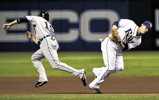 Tampa Bay Rays second baseman Reid Brignac, right, tags out Detroit Tigers' Jeff Larish (19) after fielding a ground ball hit by Brennan Boesch during the first inning of a baseball game Wednesday, July 28, 2010, in St. Petersburg, Fla. Brignac made the throw in time to complete a double play on Boesch at first base.