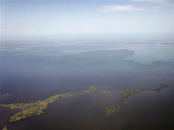 A large sheen of oil from the Deepwater Horizon oil spill, background, is seen approaching Timbalier Island in the Gulf of Mexico, off the coast of Louisiana, Wednesday, July 28, 2010. (AP Photo/Gerald Herbert)