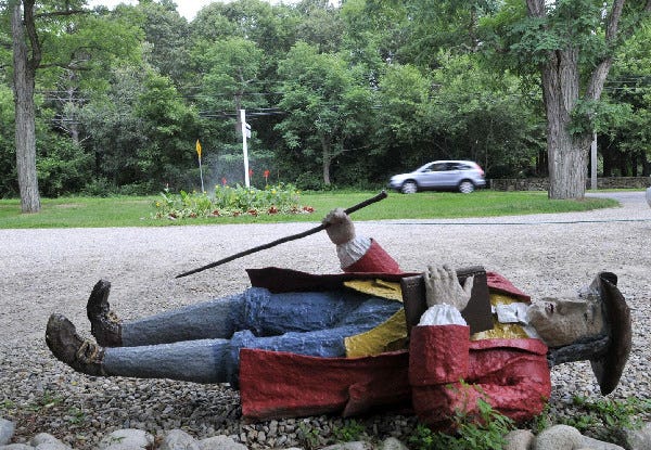 The 37-year-old steel Colonial statue lies in the parking lot at Titcomb's Bookshop in Sandwich yesterday. The famous figure in town was accidentally struck by a car July 17. "People have said he's a citizen of the town, he has to be put back even if he has a peg leg," Nancy Titcomb said.