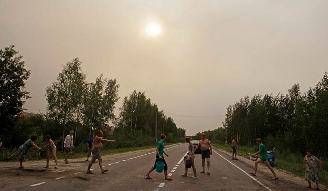Residents make a human chain Thursday to carry buckets of water to a peat 
fire in a forest near the town of Shatura, 81 miles southeast of Moscow. 
ASSOCIATED PRESS / SERGEY PONOMAREV