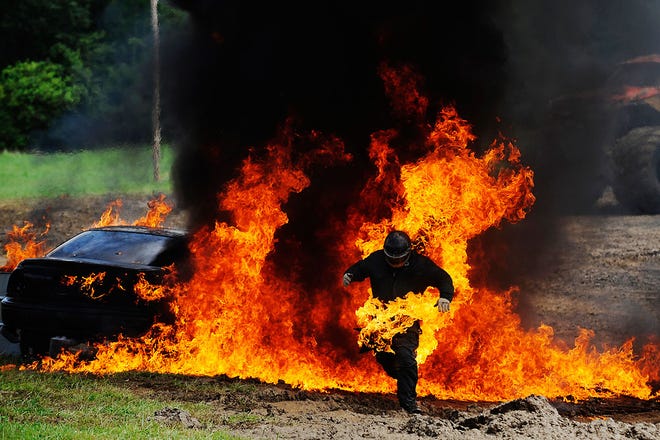 Daredevil John Anderson Jr., aka Johnny Thunder of Decatur, Ind., runs from a burning car after a stunt at the Boone County Fair. The stunt involved Anderson getting into the car, igniting 20 gallons of gasoline and escaping. He was not hurt.