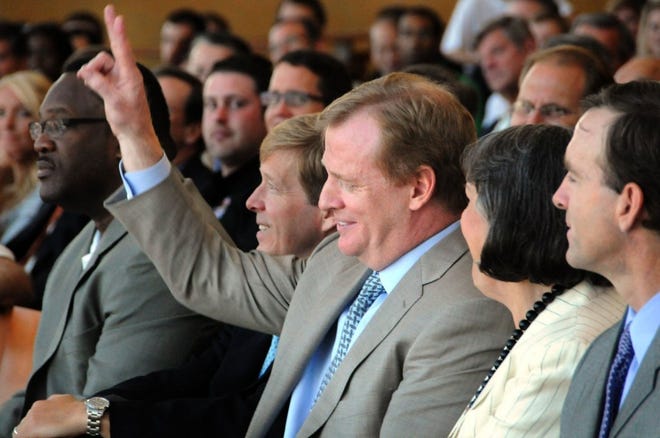 NFL commissioner Roger Goodell, sitting between Mayor John Peyton and Delores Barr Weaver, raises two fingers to indicate how many balls he hit into the water on the 17th hole at TPC Sawgrass in 1993, when Goodell was on the committee that brought the Jaguars to Jacksonville.
