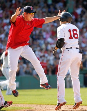 Marco Scutaro (16) is greeted by Diasuke Matsuzaka, after hitting the game-winning bunt-single during the ninth inning of the Red Sox' 4-3 victory on Sunday at Fenway Park.