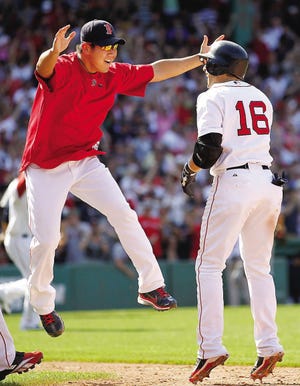 Marco Scutaro (16) is greeted by teammate Daisuke Matsuzaka after hitting a game-winning bunt single in the ninth inning of Boston’s 4-3 win over the Detroit Tigers Sunday at Fenway Park.