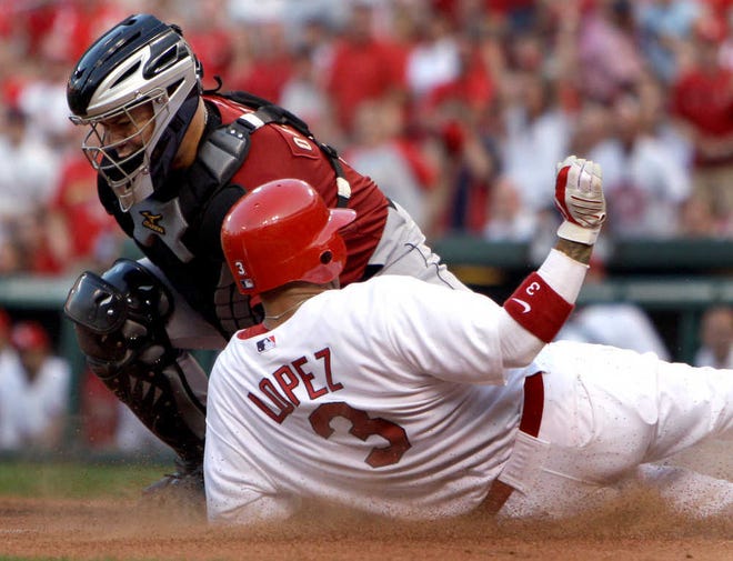 St. Louis Cardinals' Felipe Lopez (3) scores ahead of the tag from Houston Astros catcher Humberto Quintero during the first inning of a baseball game Monday, Aug. 2, 2010, in St. Louis. (AP Photo/Jeff Roberson)