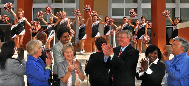 Ed Pratt-Dannals (center right), Duval County superintendent of schools, joins others in applauding the Atlantic Coast High School Stingray cheerleaders at Wednesday's ribbon-cutting ceremony. The school at Baymeadows Road and Florida 9A is designed to accommodate 2,300 students.