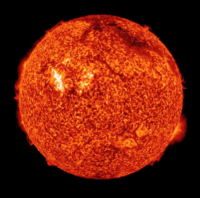 In this x-ray photo provided by NASA, the sun is shown early in the morning of Sunday, Aug. 1, 2010. The dark arc near the top right edge of the image is a filament of plasma blasting off the surface - part of the coronal mass ejection. The bright region is an unassociated solar flare. When particles from the eruption reach Earth on the evening of Aug. 3-4, they may trigger a brilliant auroral display known as the Northern Lights.
