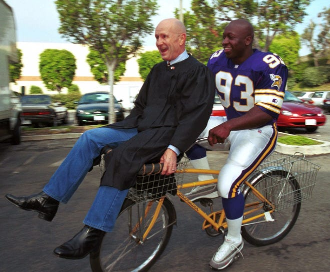 John Randle (right) and former boxing judge Mills Lane enjoy a break during the filming of a television commercial in Culver City, Calif., on June 25, 1999. Randle and Lane, then a judge on a TV court show, were featured together in the commercial.