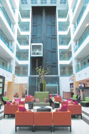 The new Holiday Inn has a five story glass-ceilinged atrium and modernist interior decor by Kirti Patel and Martyne Kapciunas.