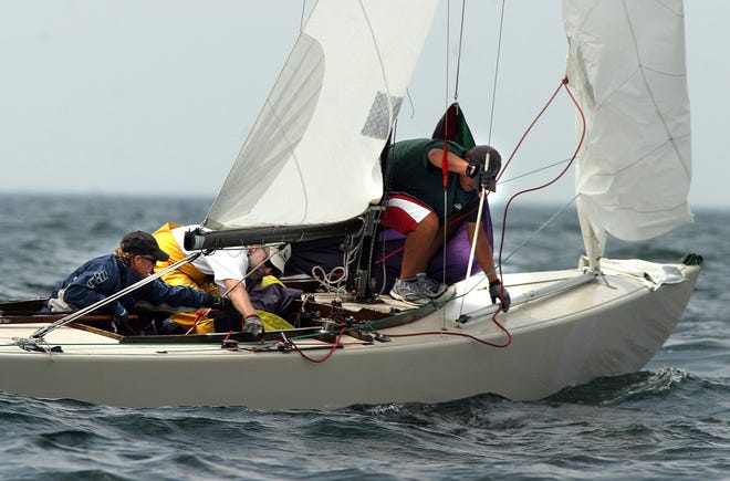 Skipper Gordon Baird, left, leans in to help crew member Mark Lindsay as Chris Palmieri stows the spinnaker pole during the first race of the day Tuesday Aug. 3 of the 210 class National Championship being held off Gloucester. The event is being sponsored by the Eastern Point Yacht Club.