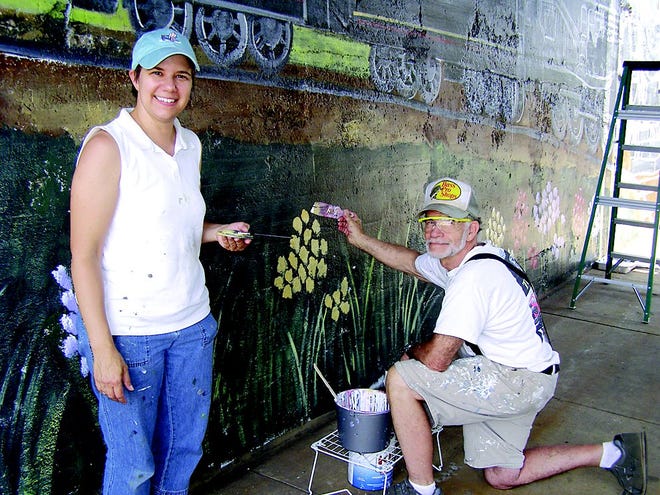 Mary DuBois and her father Tom brought the railroad underpass mural back to life last week.