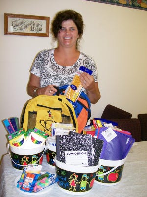 Rebecca Lipes of Victory Church of Christ in Geneseo displays a sampling of the school supplies church members will give out on Aug. 7.