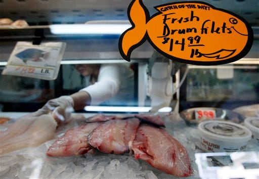 In this Aug. 6, 2010 photo, Connie Plessala places fish on ice behind the counter of Big Fisherman Seafood in New Orleans. The rich fishing grounds of the Gulf of Mexico are beginning to reopen more than three months crude began gushing from the sea floor. But those who harvest, process and sell the catch face a new crisis _ convincing wary consumers it's not only delicious, but also safe. (AP Photo/Patrick Semansky)