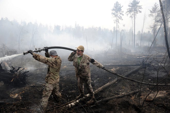A crew with the Emergency Services fights a forest fire last week near the 
village of Plotava near Moscow. In a summer of extreme heat, drought, crop 
failures and a nationwide eruption of wildfires, the Russian government is 
facing a rare upwelling of anger.NEW YORK TIMES / JAMES HILL