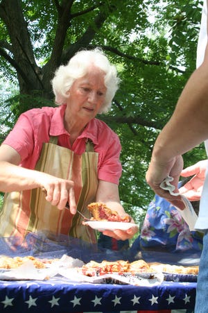 Cheryl Dowell serves up another piece of homemade pie during the 2009 Ice Cream Social and Pie in the Park in Bishop Hill’s village park.