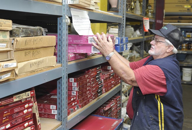 Ken Mowery organizes boxes of closet organizers, donated by Lowe’s to The Stock Pile, a non-profit warehouse selling new and used housing materials.