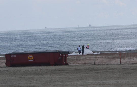 Workers search for signs of oil on a beach in Grand Isle, La. on Sunday. The beach in Grand Isle reopened to the public on Monday for the first time since they were closed in the aftermath of the Deepwater Horizon oil spill. By TY HINTON, ty.hinton@staugustine.com
