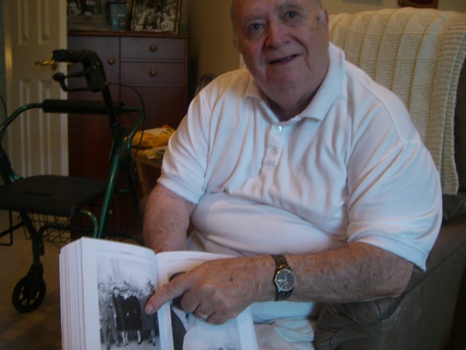 Author and Holocaust survivor Kurt Ladner points out a picture of the Greenblatt family, who sponsored his immigration to the United States in 1947.